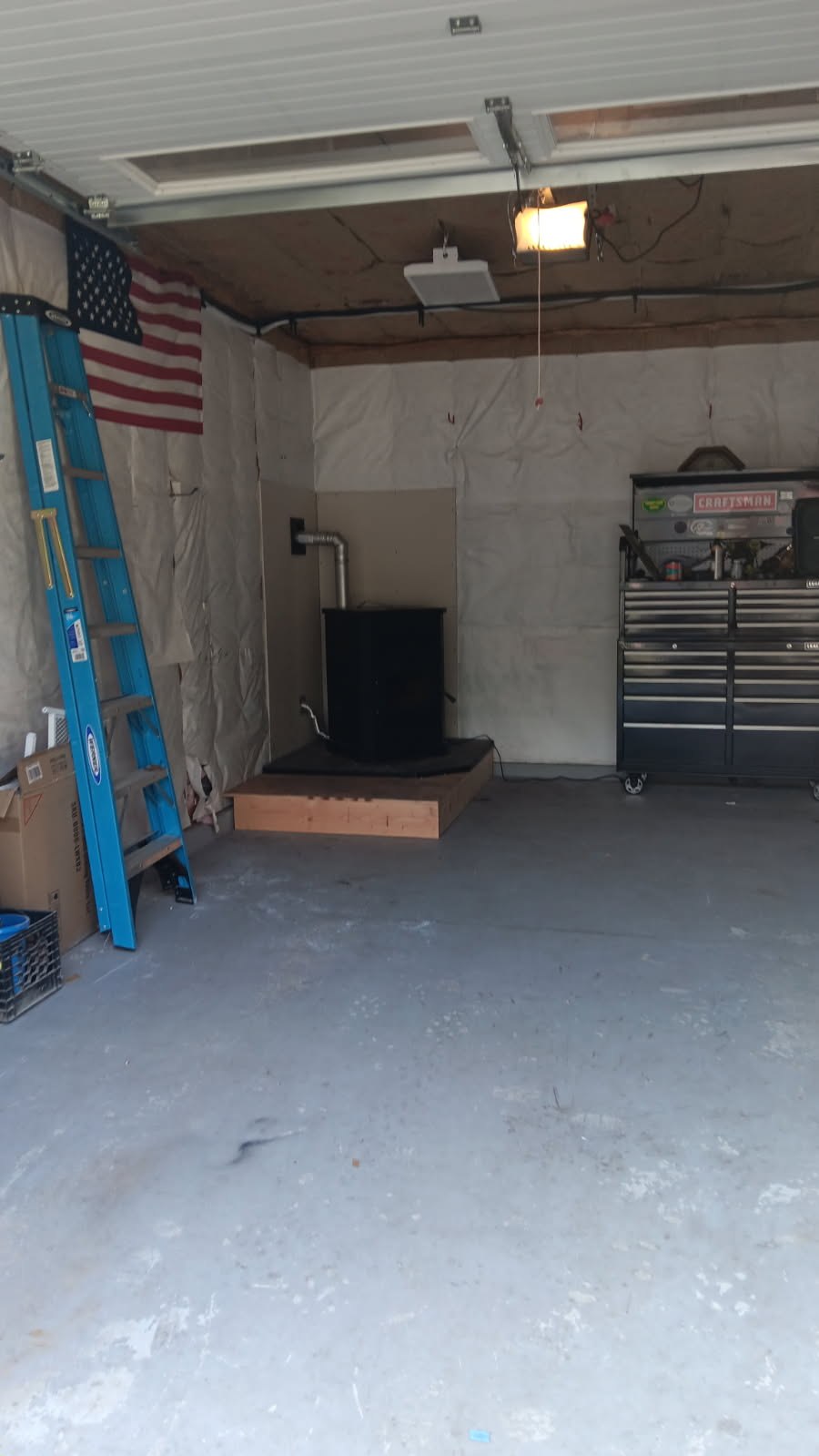 Wide view of the pellet stove and raised platform within the existing Bennington garage.