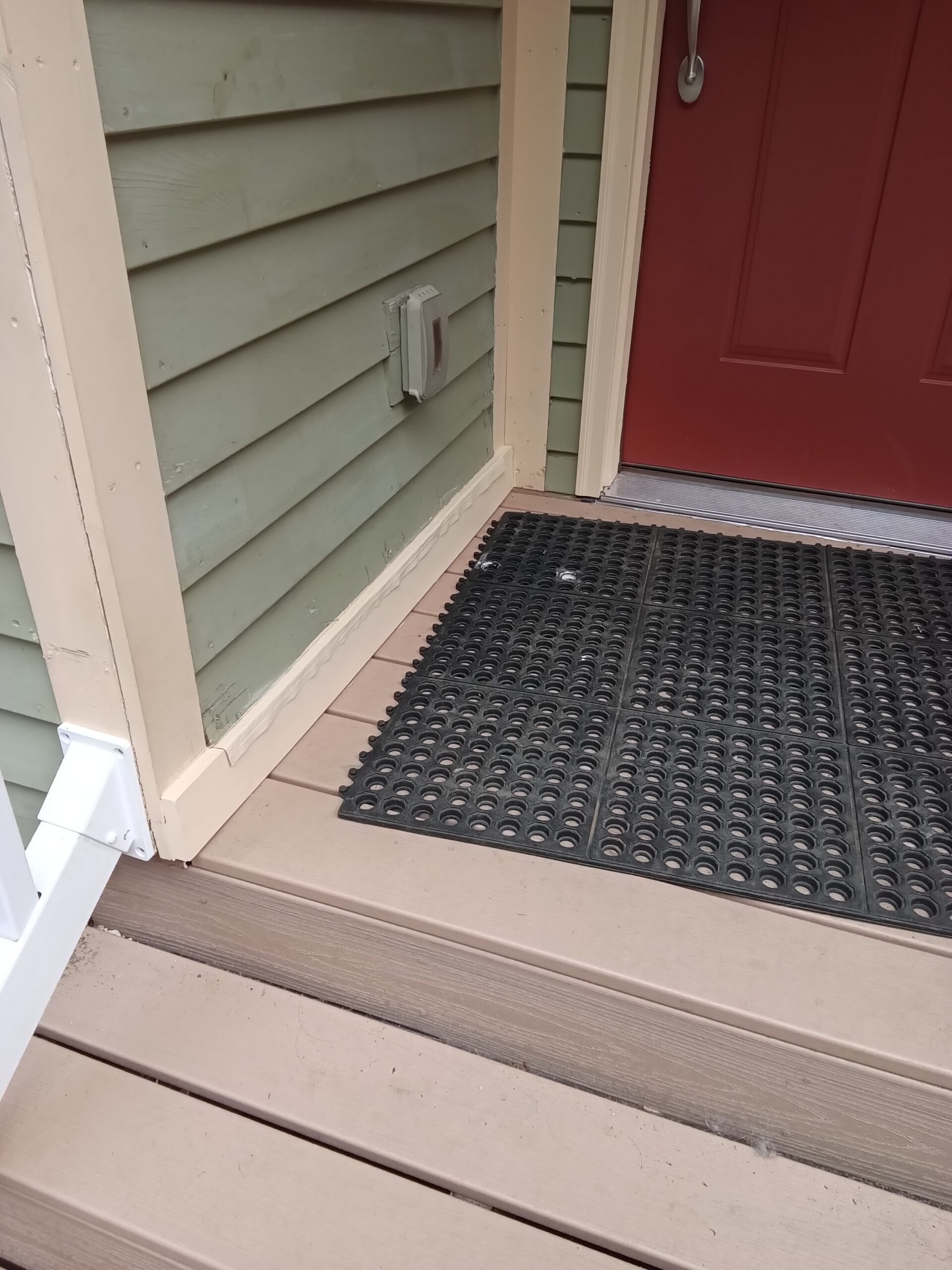 Troy doorway during installation, with replaced decking, reinstalled railing, and trim awaiting paint.